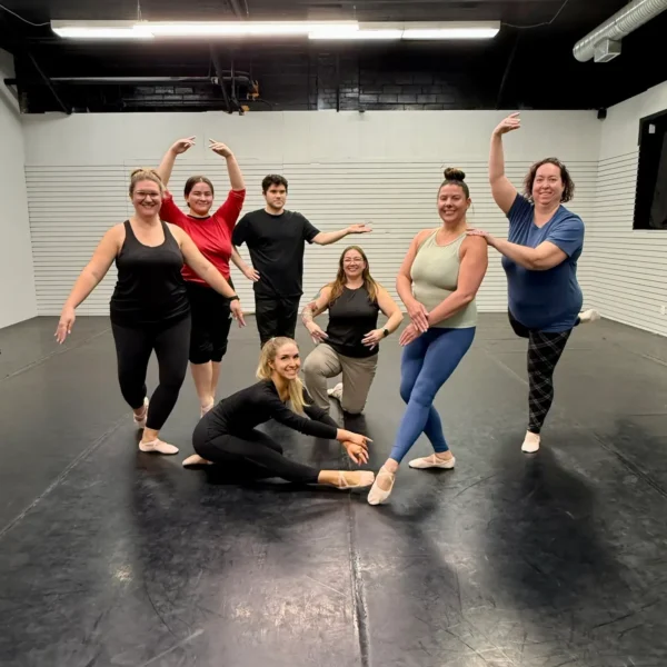 Adult ballet students posing together during a group class at Ark Dance Academy