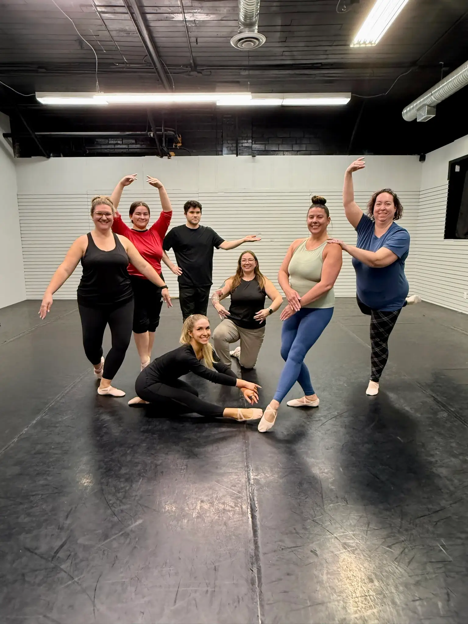 Adult ballet students posing together during a group class at Ark Dance Academy